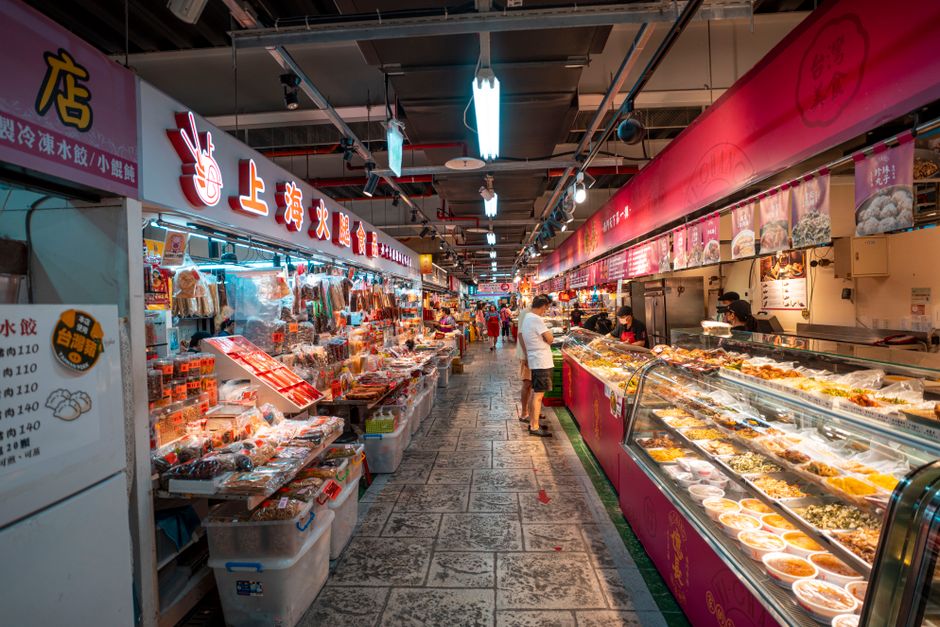 Explore a bustling Asian market with colorful food displays and busy shoppers.