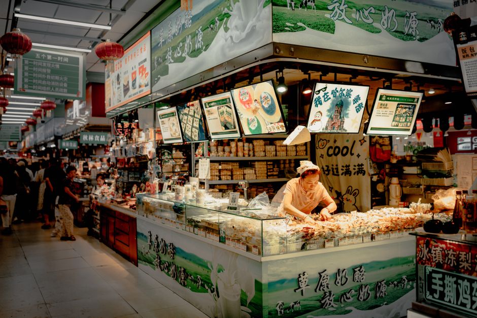 Vibrant scene of an indoor market food stall with various products on display.