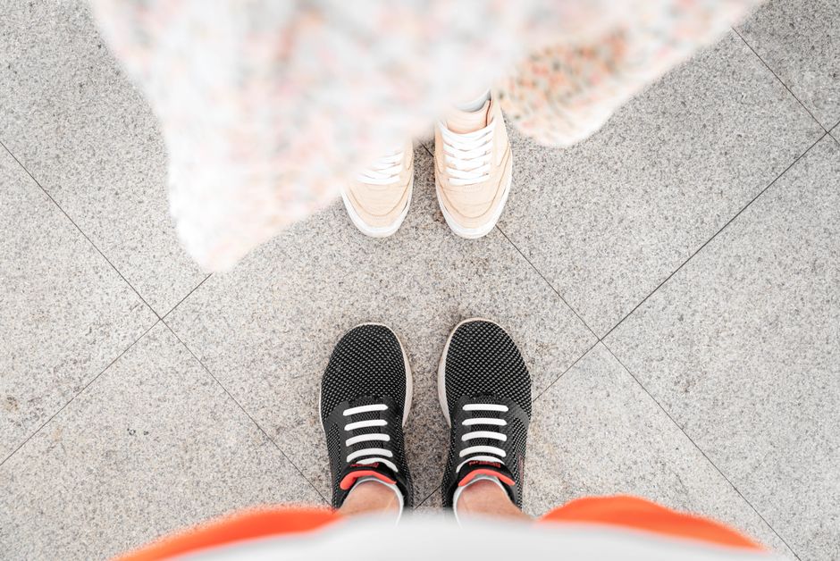 Two pairs of stylish sneakers on city pavement, perfect for fashion and lifestyle themes.
